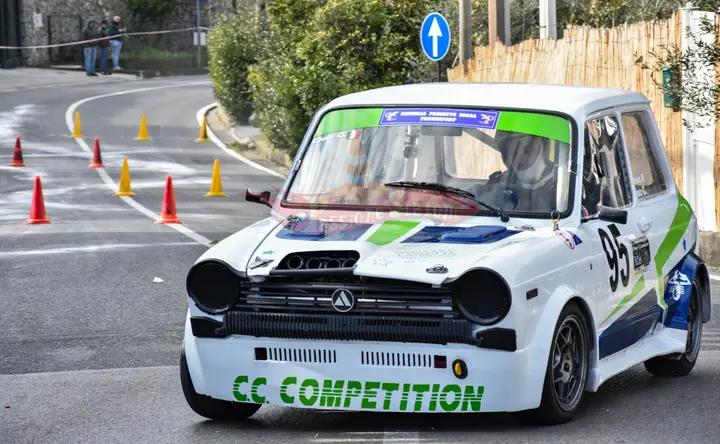 Autobianchi A112 numero 95 della C.C. Competition in uscita dal gruppo di birilli, con il pubblico dietro il nastro a bordo strada.